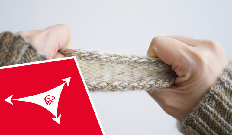 Zwei Hände ziehen ein Stück gestrickten Wollstoffs auseinander, um dessen Dehnbarkeit zu demonstrieren. Der Stoff ist cremefarben mit beigen und grauen Fäden durchzogen. In der linken unteren Ecke ist ein rotes Feld mit einem weißen Symbol: drei Pfeile, die in unterschiedliche Richtungen zeigen, symbolisieren Elastizität. In der Mitte des Symbols befindet sich das Giesswein-Logo.