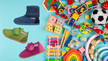 Drei bunte Kinderschuhe mit Klettverschluss neben verschiedenem Holzspielzeug auf türkisfarbenem Hintergrund