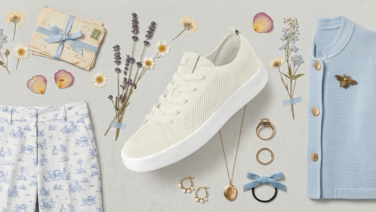 Flatlay eines femininen Frühlingsoutfits in Creme und Hellblau: gemusterte Hose, hellblaue Strickjacke, cremefarbener Giesswein Merino-Sneaker sowie Accessoires wie Halskette, Haarband, dekoriert mit Trockenblumen.