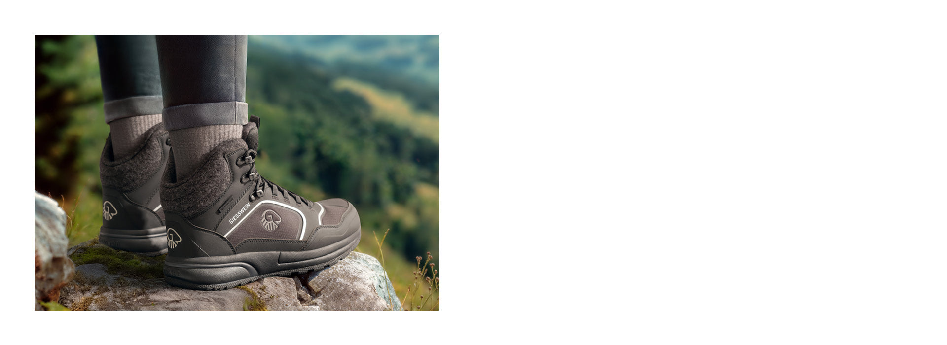 Nahaufnahme von zwei Füßen in dunkelgrauen, knöchelhohen Wanderschuhen (Wool Cross X Alpine von Giesswein) mit Wollfutter, die auf einem Felsen stehen. Die Schuhe tragen das Giesswein-Logo und befinden sich in einer grünen, leicht verschwommenen Berglandschaft mit Blumen im Vordergrund.