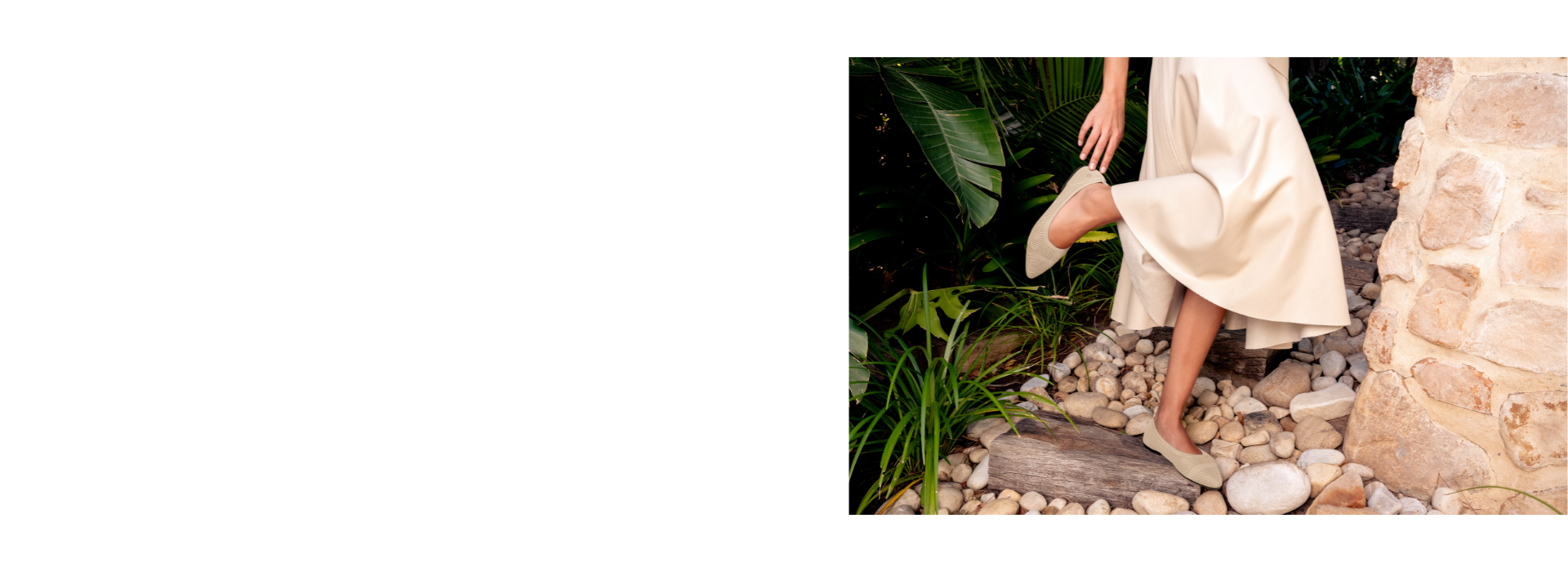 Eine Person mit cremefarbenem, fließendem Kleid steigt barfuß in beigefarbenen Ballerinas (Eco Ballerinas von Giesswein) eine kleine Steintreppe hinauf.