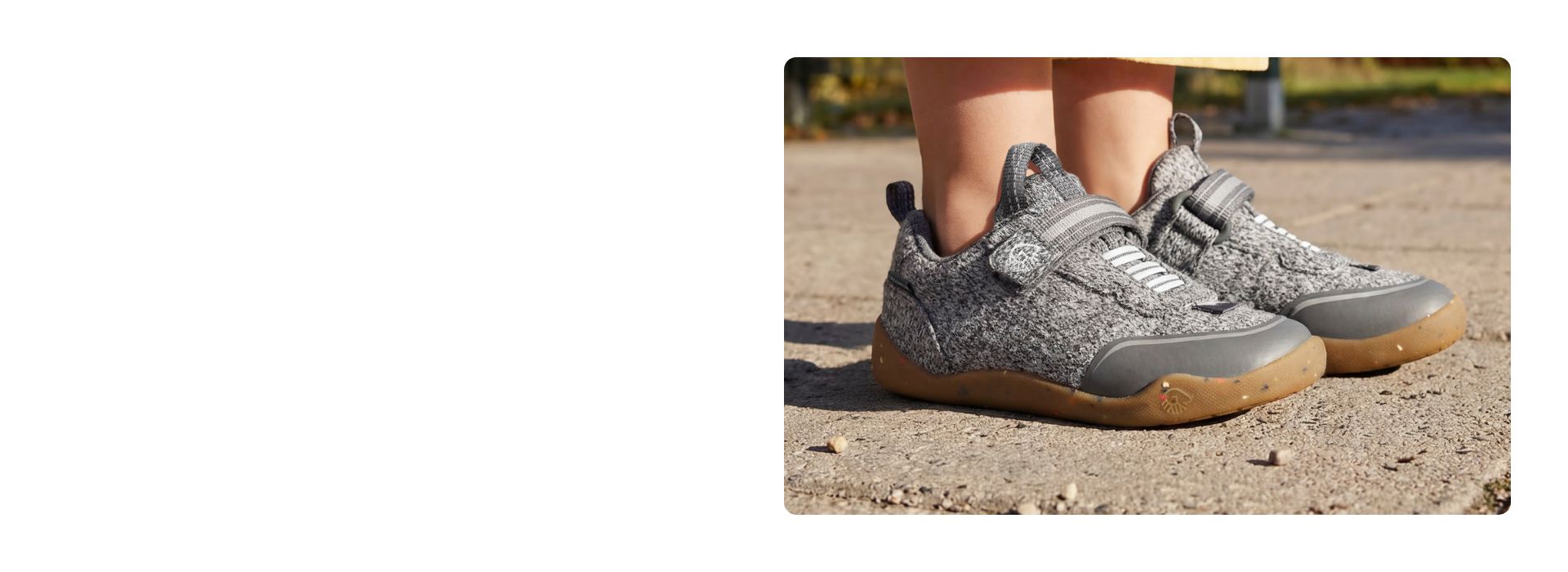 Nahaufnahme grauer Giesswein Kinder-Sneaker mit Merino-Obermaterial, Klettverschluss und honigfarbener Sohle auf einem Weg.
